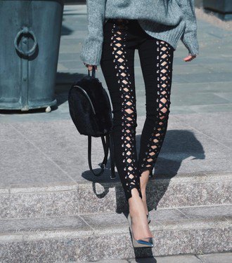 grå, grovstickad tröja med svarta läderbyxor med spetsringning