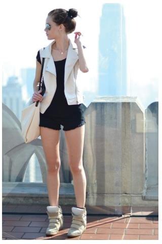 vit ärmlös kavajväst med svarta mini-shorts och rodnande sneakers
