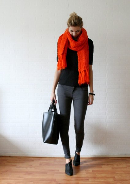 svart tröja med orange fransad halsduk och grå skinny jeans