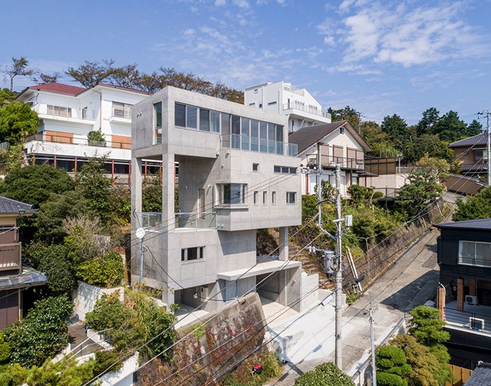 ashida arkitekter sätter betongatamitornhus i en brant sluttning.