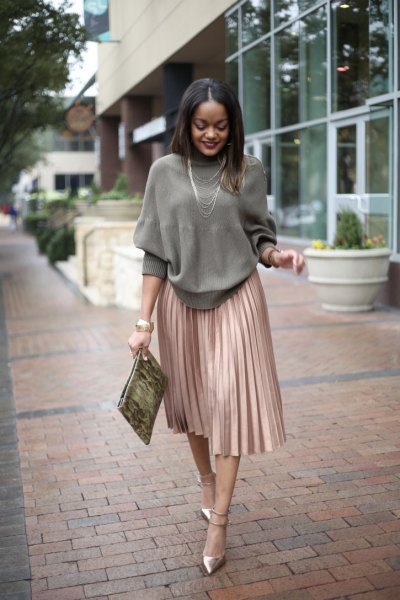 grå stickad tröja med rund halsringning och rosa guldfärgad veckad kjol