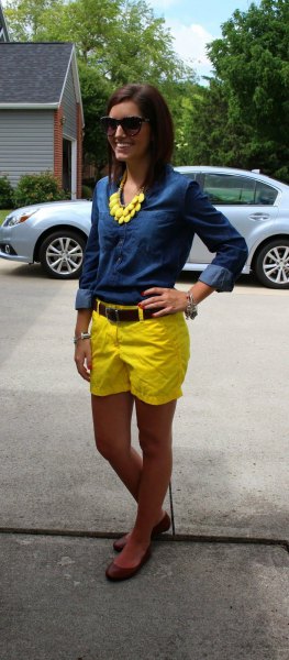 blå chambrayskjorta med knappar och gula shorts