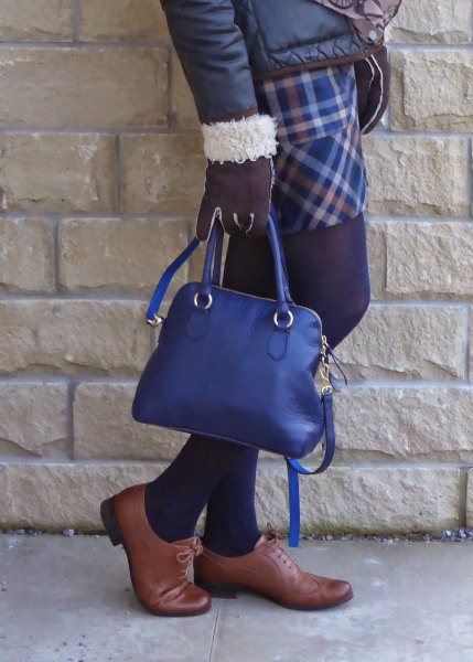 svart dunjacka med rutig kjol och djupblå handväska