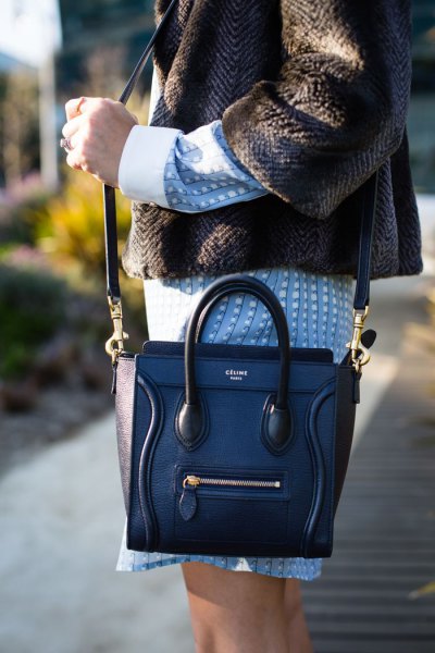 mörkblå läderhandväska med tweedjacka och blå klänning