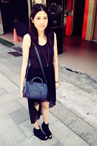 svart ärmlös klänning med hög chiffong och scoop halsringning och mörkblå handväska
